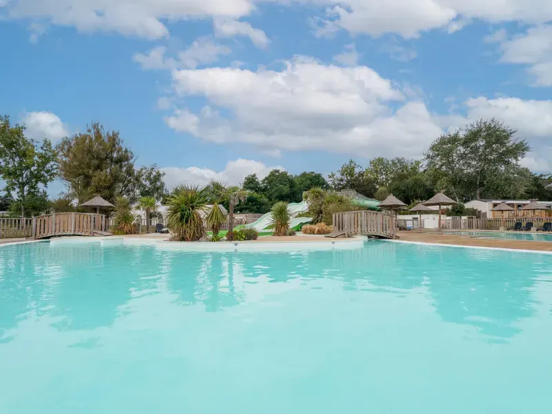 Buitenzwembad met houten chalets op de achtergrond