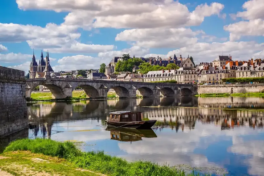 Rivier met boogbrug en stad op de achtergrond